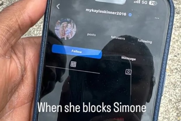 Joran Chiles and Simone Biles are seen in the reflection of the phone