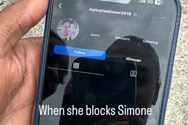 Joran Chiles and Simone Biles are seen in the reflection of the phone