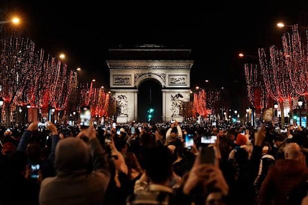 People celebrate the New Year's Eve on the Champs Elysees avenue, in Paris, Friday, Dec. 31, 2021.