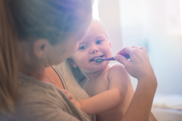 A stock photo of a Toddler (boy) having is teeth brushed with the help of his Mother. Photographed using the Canon EOS 1DX Mark II.