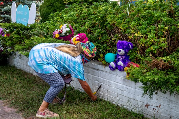 Dawn Bartell of Bohemia, NY brings flowers for Gabby Petito's memorial alongside Montauk Hwy in Blue Point, New York.