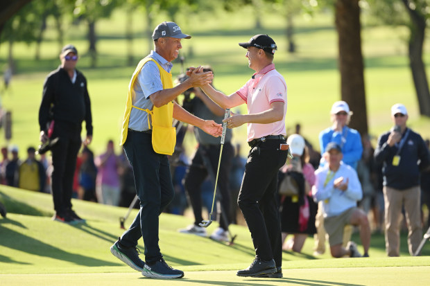 Justin Thomas of the United States reacts to his winning putt on the 18th hole with caddie Jim "Bones" Mackay, the third playoff hole during the final round of the 2022 PGA Championship at Southern Hills Country Club.