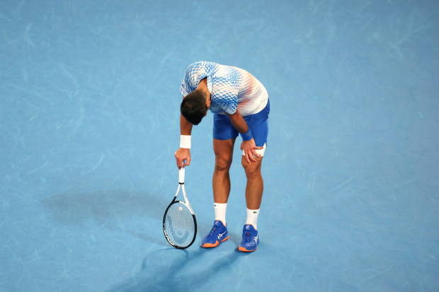 Novak Djokovic down on his haunches after nearly losing the first set to Tommy Paul.