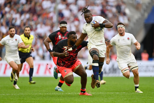 Maro Itoje of England breaks through the tackle of Luke Tagi of Fiji.