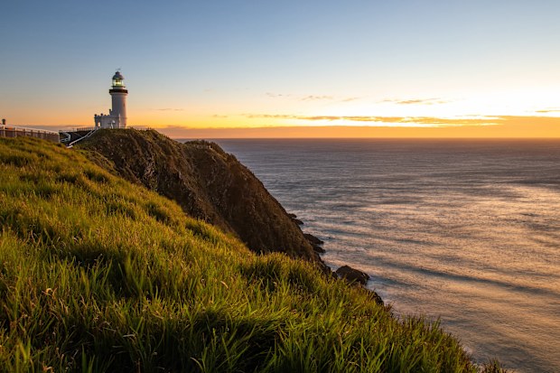 Cape Byron Lighthouse stands tall against the vibrant sunset sky in Byron Bay, New South Wales
