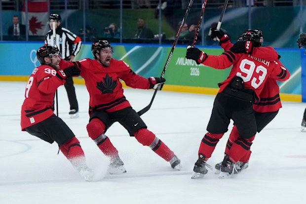 Canada's Brandon Hagel (38), Mark Stone (61), Mitch Marner (93) and Macklin Celebrini (17) celebrate after Marner scored the winning goal during the overtime period of a men's ice hockey quarterfinal game between Canada and Czechia at the 2026 Winter Olympics, in Milan, Italy, Wednesday, Feb. 18, 2026. (Darryl Dyck/The Canadian Press via AP)