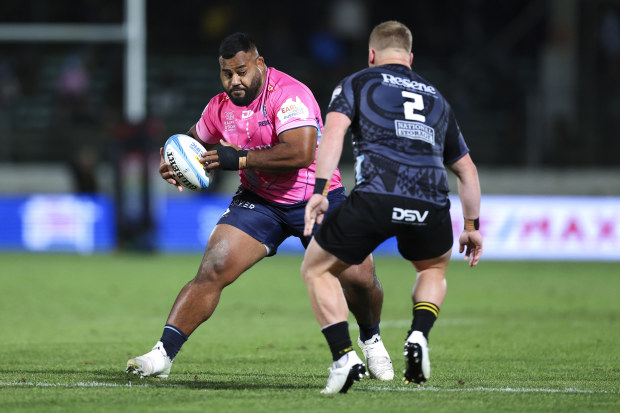 Taniela Tupou of the Rebels attempts to evade James O'Reilly of the Hurricanes.