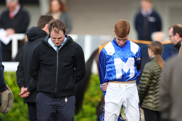 Jockey Daniel Muscutt observes a minute's silence as a mark of respect to Stefano Cherchi at Kempton Park in England.