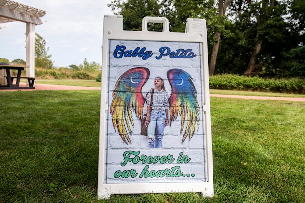 People donate money and distribute candles that will be later be lit in unison in support of the Petito family in Blue Point Nature Preserve park in New York.