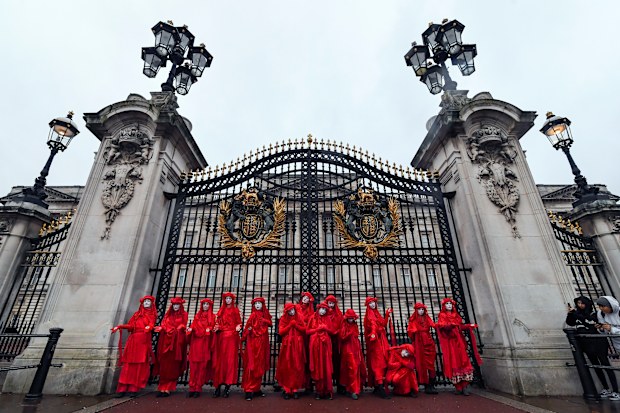 Climate activists pose for the media outside Buckingham Palace during an Extinction Rebellion protest in London, Monday, Oct. 7, 2019. 