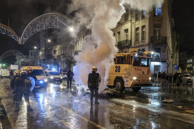 Riot police officers stand on a main boulevard in Brussels, Sunday, Nov. 27, 2022, as violence broke out during and after Morocco's 2-0 win over Belgium at the World Cup. Police had to seal off parts of the center of Brussels and moved in with water cannons and tear gas to disperse crowds. (AP Photo/Geert Vanden Wijngaert)