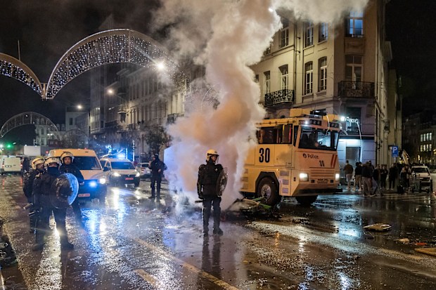 Riot police officers stand on a main boulevard in Brussels, Sunday, Nov. 27, 2022, as violence broke out during and after Morocco's 2-0 win over Belgium at the World Cup. Police had to seal off parts of the center of Brussels and moved in with water cannons and tear gas to disperse crowds. (AP Photo/Geert Vanden Wijngaert)