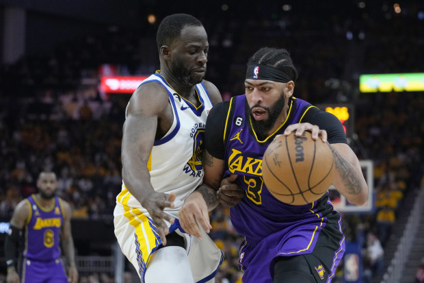 Lakers star Anthony Davis is defended by Draymond Green of the Warriors.