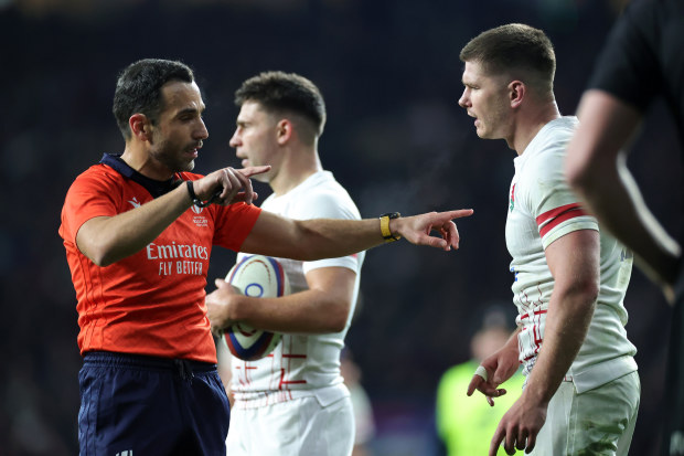 Referee Mathieu Raynal speaks with Owen Farrell of England.
