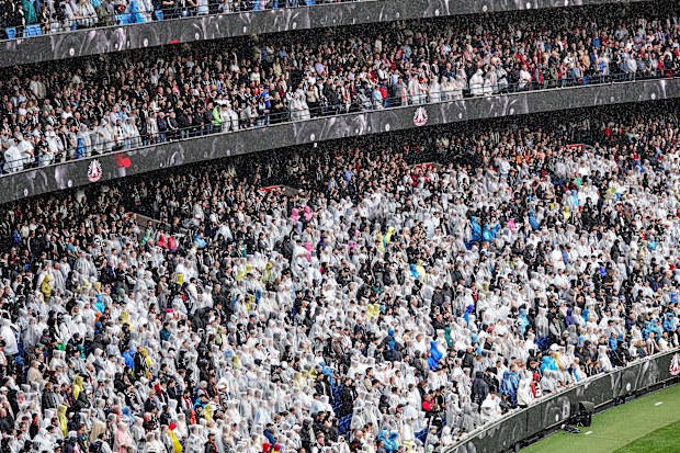 The crowd wearing ponchos in The rain during the Anzac Day match between the Collingwood Magpies and the Essendon Bombers at the MCG in Melbourne.