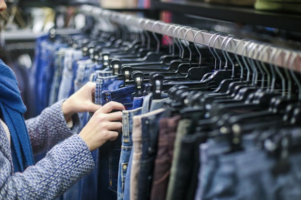 Woman looking at jeans on rack in shops