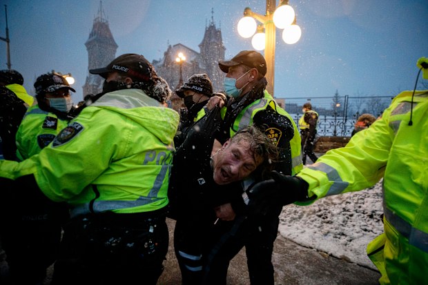 A man is arrested by police as protestors and supporters gather as a protest against COVID-19 measures that has grown into a broader anti-government protest continues to occupy downtown Ottawa on Thursday, Feb. 17, 2022. 