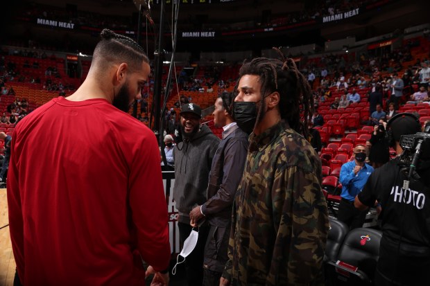 MIAMI, FL - JANUARY 26: Rapper, J. Cole talks with Caleb Martin #16 of the Miami Heat before the game against the New York Knicks on January 26, 2021 at FTX Arena in Miami, Florida. NOTE TO USER: User expressly acknowledges and agrees that, by downloading and or using this Photograph, user is consenting to the terms and conditions of the Getty Images License Agreement. Mandatory Copyright Notice: Copyright 2022 NBAE (Photo by Issac Baldizon/NBAE via Getty Images)