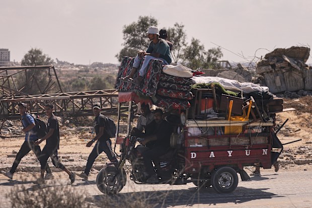 Displaced Palestinians walk along the coastal road as they move in the direction of Gaza City,