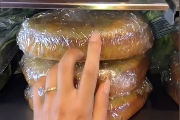 Laura Saxe showing her followers the stacked cakes in her fridge ready for icing and assembling.