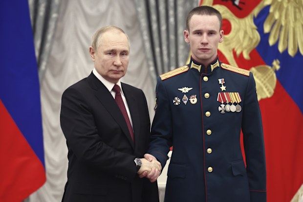 Russian President Vladimir Putin, left, awards Senior Lieutenant Stepan Belov with the Gold Star medal of the Hero of Russia during an awarding ceremony at the Kremlin's St. Catherine Hall in Moscow, Russia, Tuesday, Dec. 20, 2022 