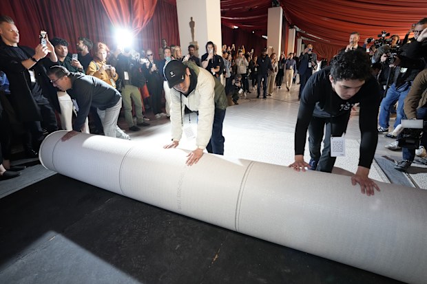 Crew members roll out the carpet outside the Dolby Theatre on Wednesday, March 8, 2023, in Los Angeles in preparation for Sunday's 95th Academy Awards. (AP Photo/Chris Pizzello)