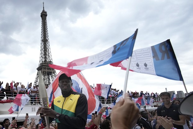 Olympics legend Usain Bolt with the torch as Paris celebrated one year until the 2024 Games.