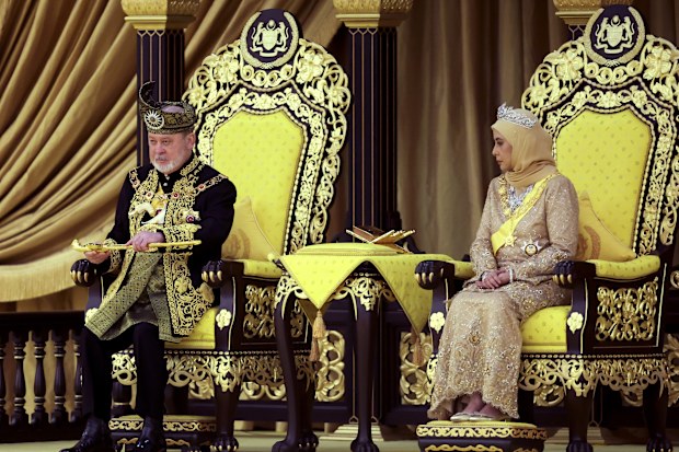 The 17th King of Malaysia, Sultan Ibrahim Iskandar, left, lifts a ceremonial dagger as Queen Raja Zarith Sofiah looks on during his coronation at the National Palace in Kuala Lumpur, Malaysia, Saturday, July 20, 2024. (Hasnoor Hussain/Pool Photo via AP)