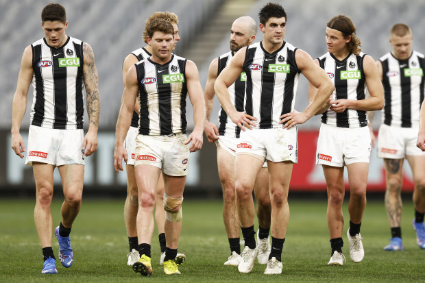 Magpies players leave the field looking dejected.