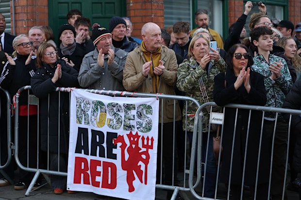 MANCHESTER, ENGLAND - DECEMBER 22:   Mourners applaud at the funeral of Gary Mounfield, also known as Mani, at Manchester Cathedral on December 22, 2025 in Manchester, England. Mani is know for being the bass guitarist in rock bands The Stone Roses and Primal Scream. He died on November 20, 2025 at the age of 63 after suffering from a long-standing lung condition.  (Photo by Ryan Jenkinson/Getty Images)