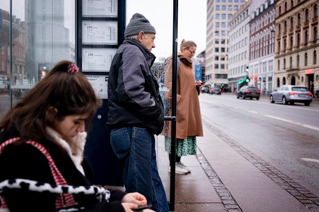 Passengers at a bus stop in Copenhagen, Denmark, Tuesday, Feb. 1, 2022. Starting Tuesday, it is no longer mandatory to wear protection mask anywhere in public in Denmark. The Danish Government decided that COVID-19 is no longer categorized as a socially critical disease after 31 January 2022, and has lifted COVID restrictions. (Liselotte Sabroe/Ritzau Scanpix via AP)