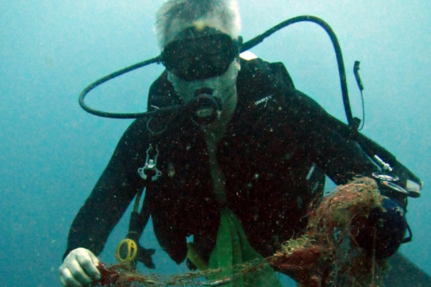 Harry Chan removes old fishing gear from the ocean.