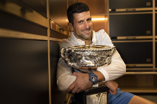 Novak Djokovic of Serbia hugs the Norman Brookes Challenge Cup.