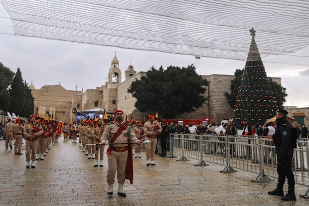 Palestinian scout bands parade through Manger Square at the Church of the Nativity,  traditionally believed to be the birthplace of Jesus Christ, during Christmas celebrations, in the West Bank city of Bethlehem, Friday, Dec. 24, 2021. 