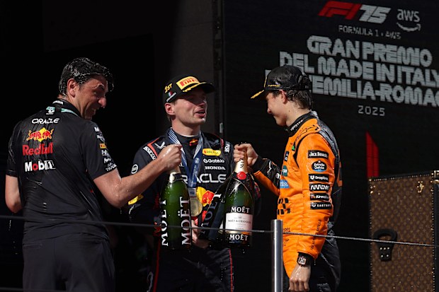 Race winner Max Verstappen and third placed Oscar Piastri of Australia celebrate on the podium.