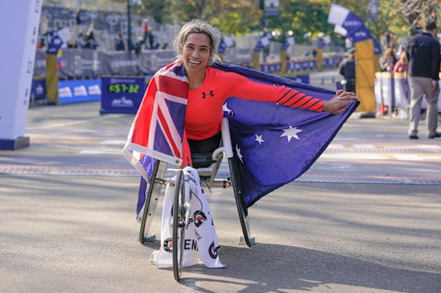 Madison de Rozario of Australia poses for a picture after crossing the finish line first in the womens wheelchair division of the New York City Marathon.