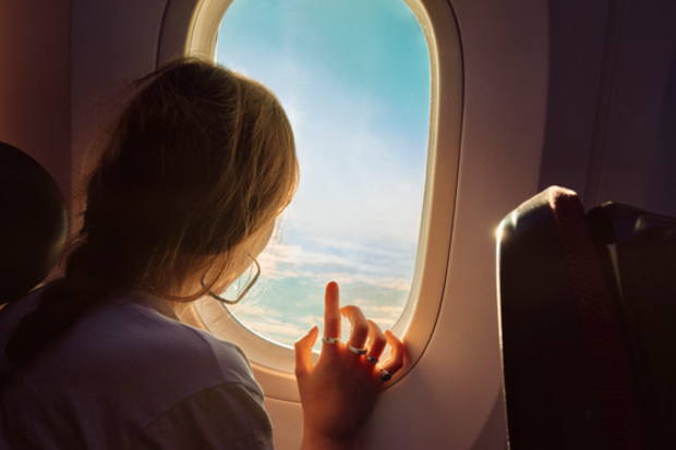 Woman looking out a plane window