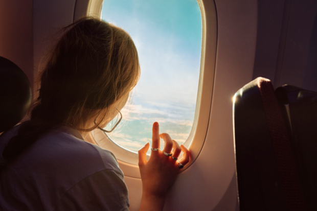 Woman looking out a plane window