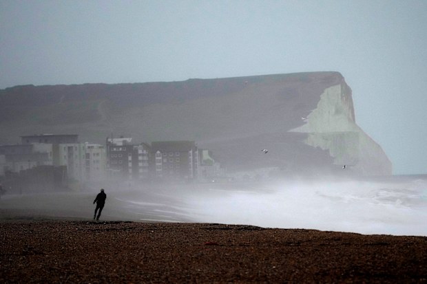 A person walks on Seaford Beach, as Storm Eunice hits Seaford and the south coast of England, Friday, February 18, 2022. 