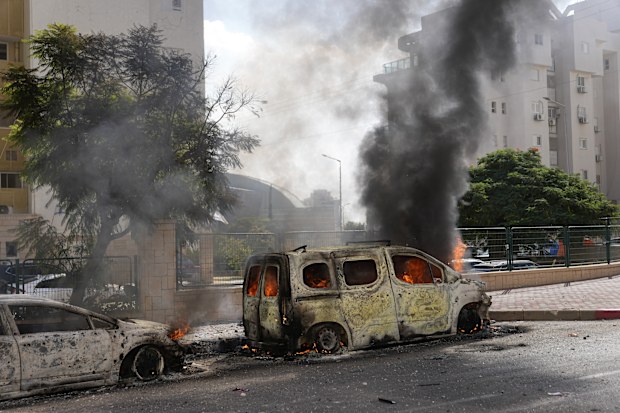 Cars are on fire after they were hit by rockets from the Gaza Strip in Ashkelon, Israel, on Saturday, Oct. 7, 2023.  