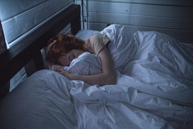 Woman asleep in bed stock photo.