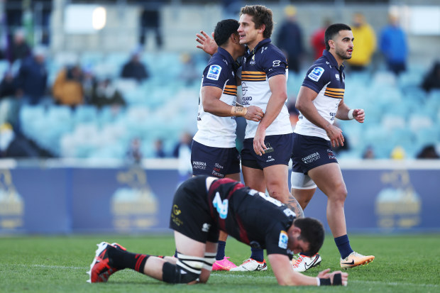 Brumbies players Tom Wright; Ollie Sapsford and Len Ikitau celebrate victory during the round 13 of Super Rugby Pacific match against the Crusaders.