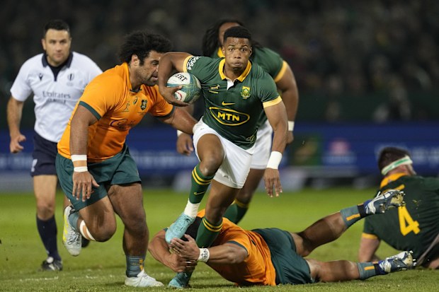 South Africa's Grant Williams jumps as he avoids a tackle from Australia's Jordan Uelese.