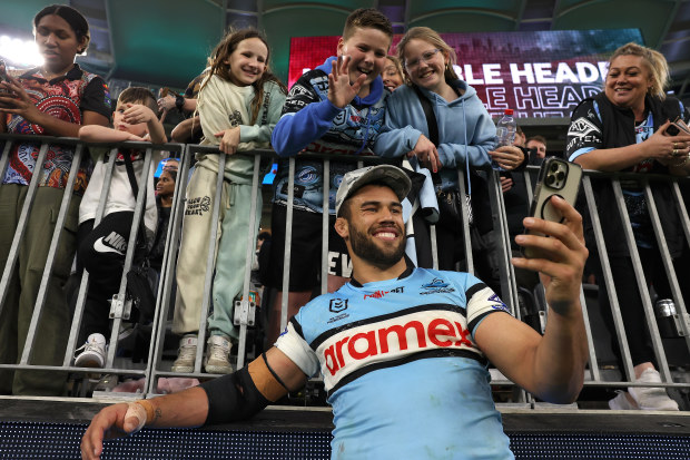 PERTH, AUSTRALIA - AUGUST 05: Toby Rudolf of the Sharks takes selfies for supporters after winning the round 23 NRL match between South Sydney Rabbitohs and Cronulla Sharks at Optus Stadium on August 05, 2023 in Perth, Australia. (Photo by Paul Kane/Getty Images)