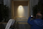 A man takes images of the tomb of Pope Francis as faithful are allowed inside St. Mary Major Basilica in Rome, Sunday, April 27, 2025. (AP Photo/Alessandra Tarantino)