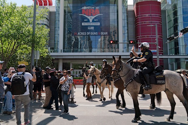 Mounted police officers tell protesters to move back across the street from the National Rifle Association annual meeting at the George R. Brown Convention Center in Houston, Friday, May 27, 2022. (AP Photo/Jae C. Hong)