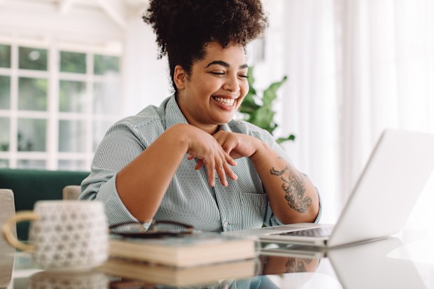 Happy woman video calling using laptop
