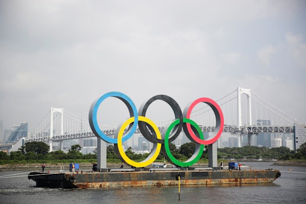 Tugboats move a symbol installed for the Olympic and Paralympic Games in Tokyo.