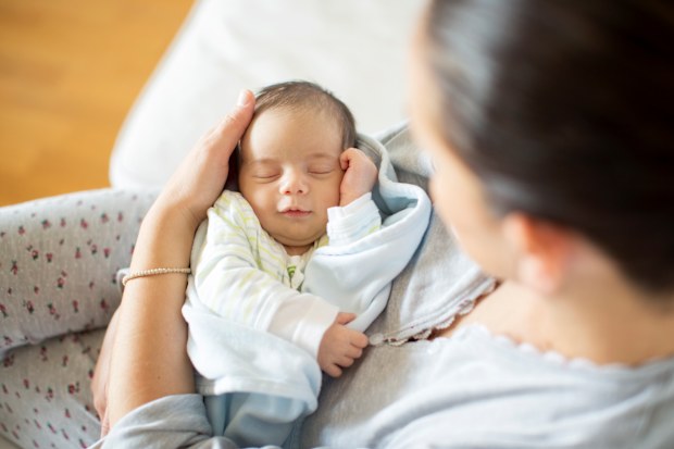 Woman holding newborn baby at home