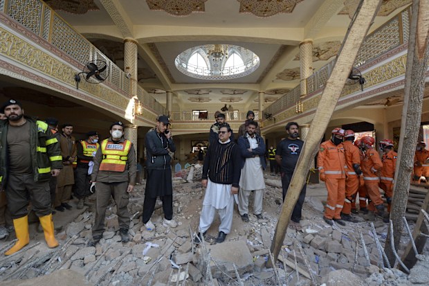 Rescue workers gather as they conduct an operation to clear the rubble and search for bodies at the site of Monday's suicide bombing.